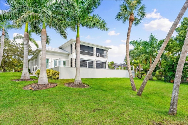 back of house featuring a sunroom and a yard