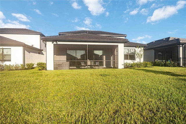 back of house with a lawn and a sunroom