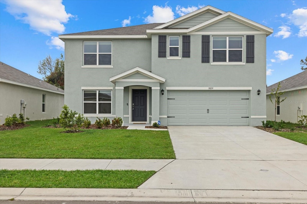 front facade with a front yard and a garage