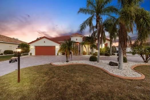 mediterranean / spanish home with a lawn and a garage