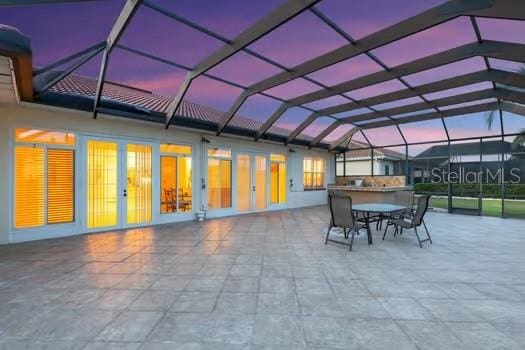 patio terrace at dusk with a lanai and french doors