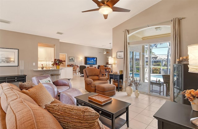 living room with ceiling fan, light tile patterned floors, and lofted ceiling