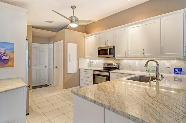 kitchen with light stone countertops, white cabinetry, sink, and appliances with stainless steel finishes