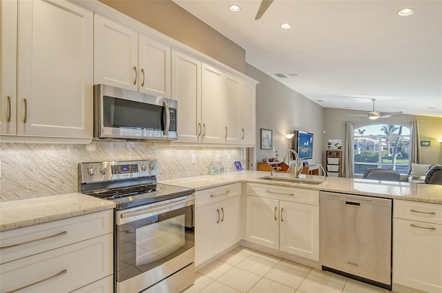 kitchen with white cabinetry, light stone countertops, sink, light tile patterned floors, and appliances with stainless steel finishes