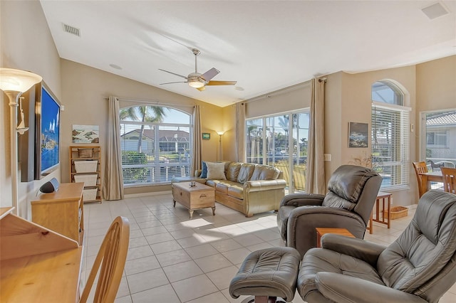 living room with vaulted ceiling, ceiling fan, a healthy amount of sunlight, and light tile patterned flooring