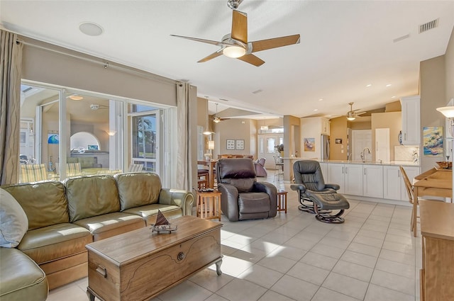 living room with light tile patterned floors, sink, and vaulted ceiling