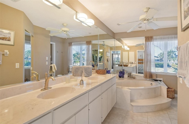 bathroom with tile patterned floors, vanity, and tiled bath