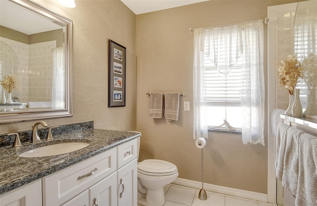 bathroom with tile patterned flooring, vanity, and toilet