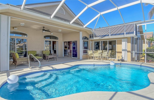 view of pool featuring glass enclosure, ceiling fan, and a patio area