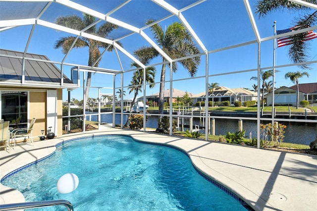 view of pool with a water view, glass enclosure, and a patio area