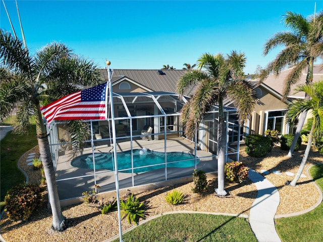 view of swimming pool featuring glass enclosure and a patio