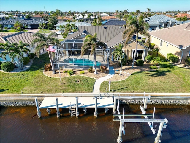 exterior space with a water view, a lanai, and a lawn