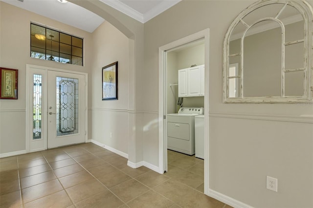 tiled foyer featuring crown molding and washing machine and clothes dryer