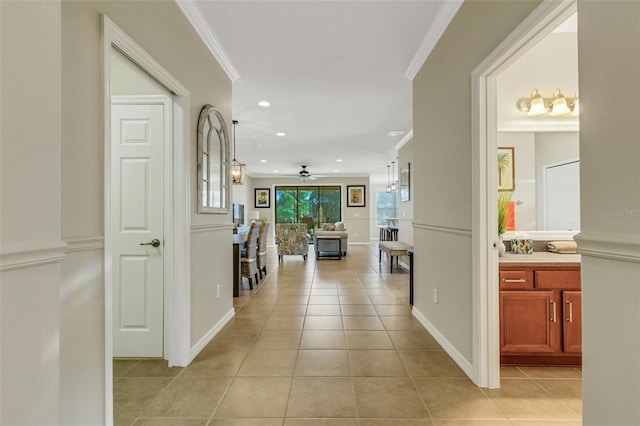 hall with crown molding and light tile patterned floors