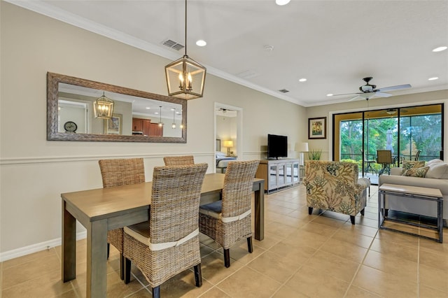 tiled dining area featuring ceiling fan with notable chandelier and crown molding