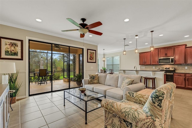 tiled living room featuring ceiling fan, a healthy amount of sunlight, and ornamental molding