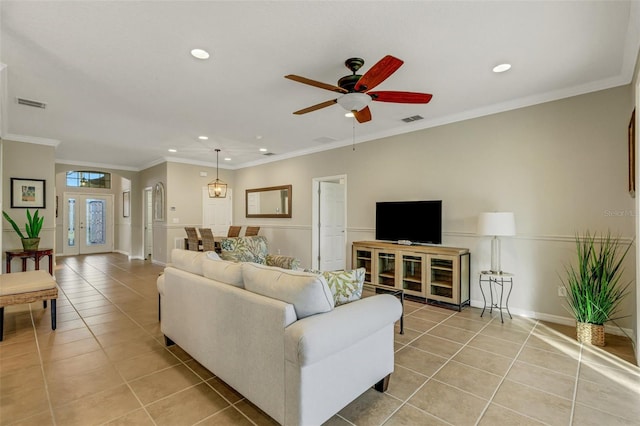 tiled living room featuring ceiling fan and crown molding