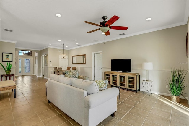 living room featuring crown molding, light tile patterned floors, and ceiling fan