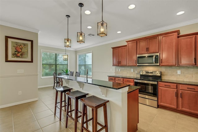 kitchen with crown molding, a center island, pendant lighting, and appliances with stainless steel finishes