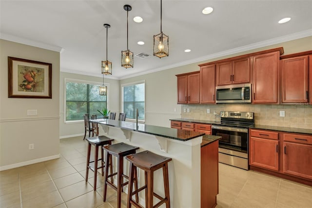 kitchen with appliances with stainless steel finishes, a center island, crown molding, and pendant lighting