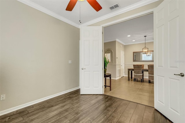 spare room featuring crown molding, ceiling fan with notable chandelier, and hardwood / wood-style flooring