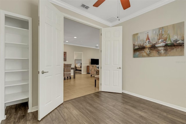 empty room featuring hardwood / wood-style flooring, ceiling fan, and crown molding