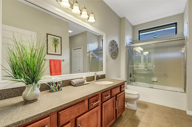 full bathroom featuring tile patterned floors, vanity, toilet, and enclosed tub / shower combo