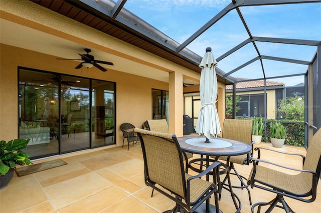 view of patio / terrace featuring ceiling fan and glass enclosure