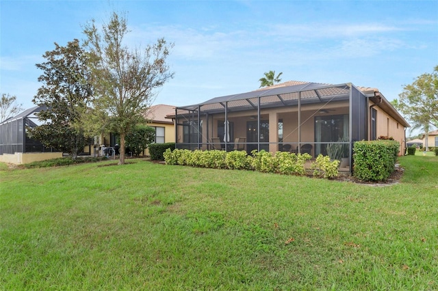 rear view of property with a lawn and a lanai