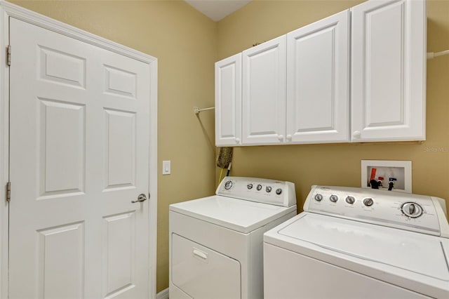 laundry room with cabinets and washing machine and clothes dryer