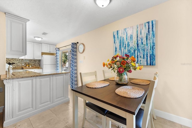 tiled dining area featuring sink