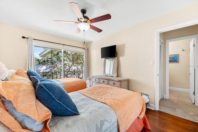 bedroom with access to outside, ceiling fan, and hardwood / wood-style flooring