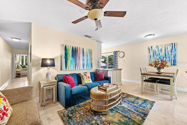 tiled living room featuring ceiling fan and a healthy amount of sunlight