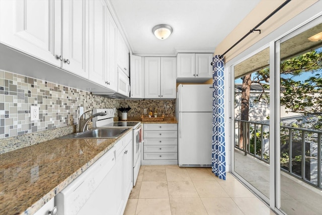 kitchen with white cabinetry, sink, stone countertops, white appliances, and light tile patterned floors