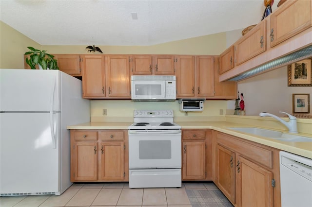 kitchen featuring lofted ceiling, white appliances, sink, light tile patterned floors, and a textured ceiling