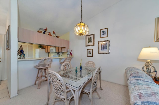 dining area featuring light carpet and an inviting chandelier