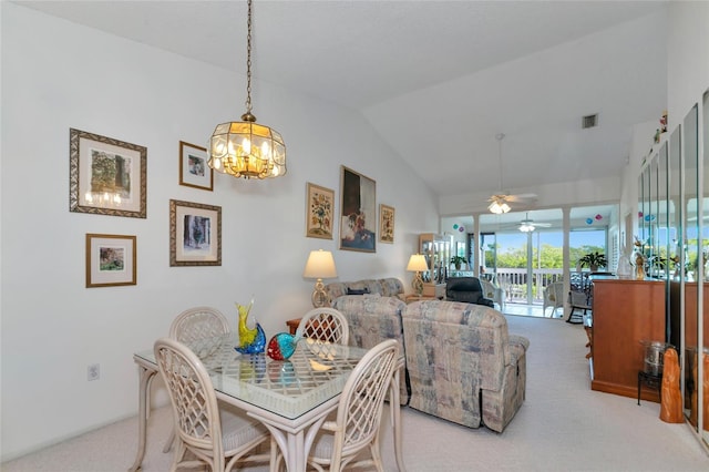 carpeted dining space with ceiling fan with notable chandelier and lofted ceiling