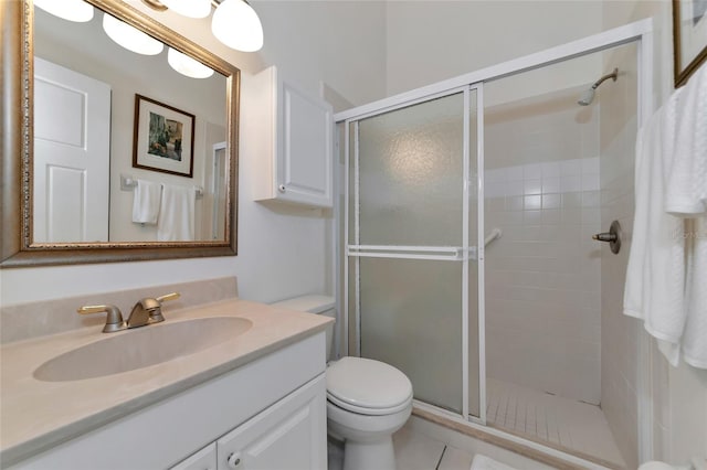 bathroom with tile patterned floors, vanity, toilet, and a shower with shower door