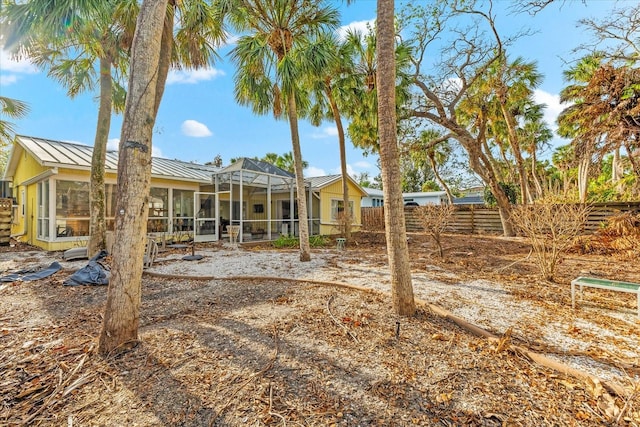 rear view of property featuring glass enclosure