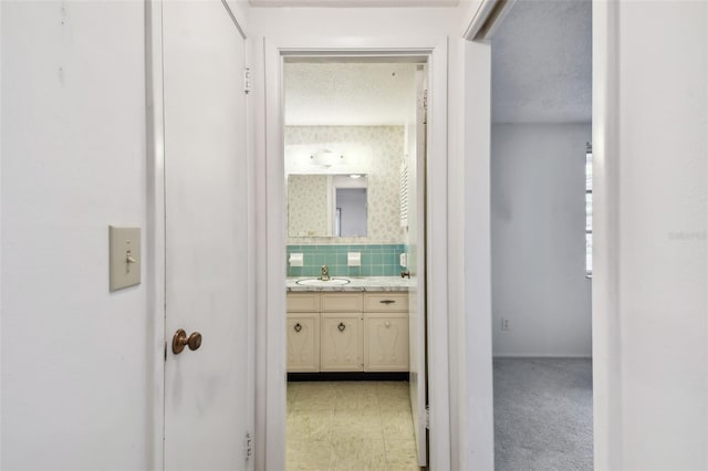 corridor featuring a textured ceiling and sink