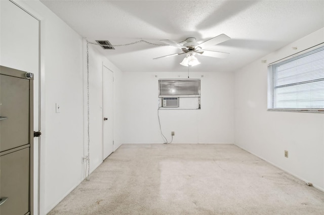 carpeted empty room with ceiling fan and a textured ceiling