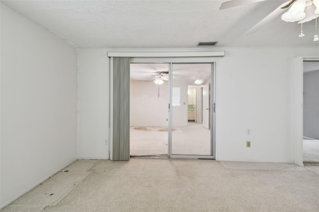 unfurnished room with light carpet and a textured ceiling