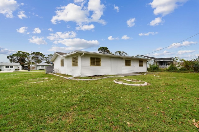 back of house with a lawn