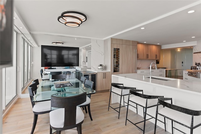 dining space featuring light wood-type flooring and sink