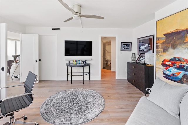 living room with ceiling fan and light hardwood / wood-style flooring