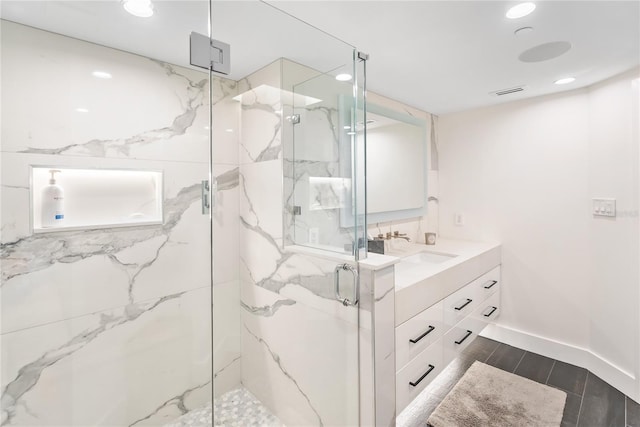 888 Blvd Of The Arts Unit 1705, Sarasota, FL 34236 - full bath with a marble finish shower, double vanity, recessed lighting, and wood finish floors