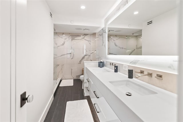 bathroom featuring hardwood / wood-style floors, vanity, toilet, walk in shower, and tile walls