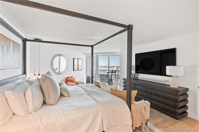 bedroom featuring access to exterior and light wood-type flooring