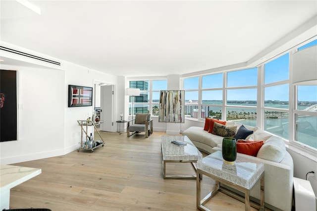 living room featuring light hardwood / wood-style floors and a water view