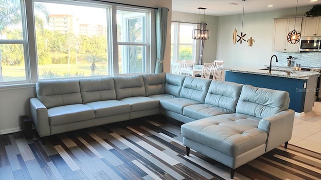 living area featuring baseboards, a notable chandelier, and recessed lighting